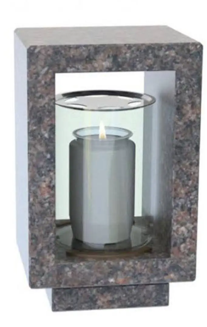 Open-frame granite memorial lantern with a central clear glass cylinder holding a lit candle.