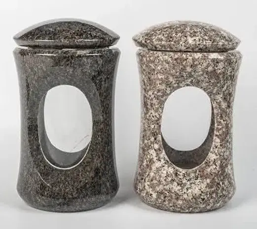 Pair of curved granite memorial lanterns, one dark and one light, each with an oval glass opening.